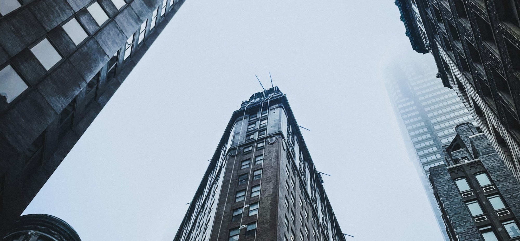 Looking up between office towers into a pale winter sky